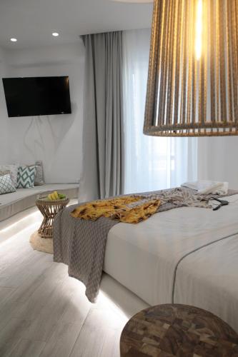 a bedroom with a large bed with a chandelier at Majestique of Naxos luxury suites in Naxos Chora