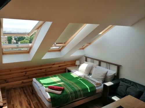 a attic bedroom with a bed and skylights at Batorego in Krakow