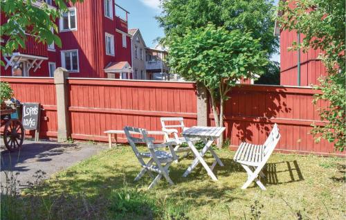 a table and chairs in front of a red fence at 3 Bedroom Nice Apartment In Vimmerby in Vimmerby