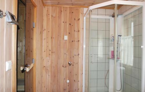 ein Bad mit einer Dusche und einer Holzwand in der Unterkunft Sjusjen Pihl 185 in Sjusjøen