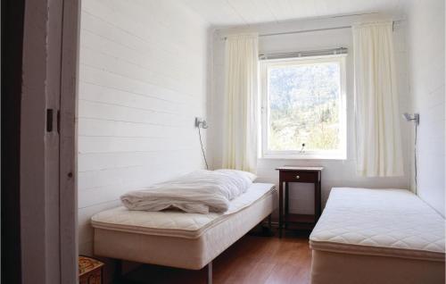 a bedroom with two beds and a window at Gorgeous Home In Eivindvik With Kitchen in Eivindvik