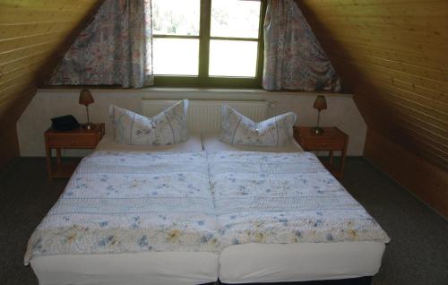 Bett in einem Zimmer mit 2 Fenstern in der Unterkunft Ferienhaus Waldstr. R in Groß Dratow