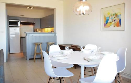 a dining room with a white table and white chairs at Residentie Emeraude 4D in Ostend