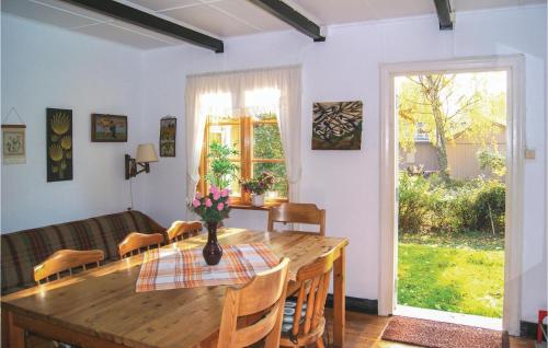 uma sala de jantar com uma mesa de madeira e um sofá em 3 Bedroom Stunning Home In Ystad em Ystad