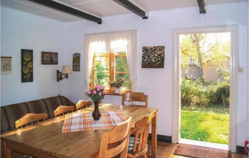 a dining room with a wooden table and a couch at Beautiful Home In Ystad With 3 Bedrooms in Ystad