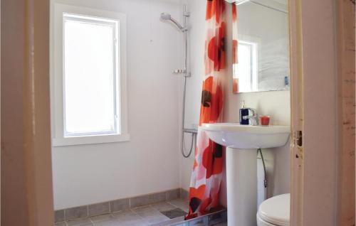 a bathroom with a sink and a toilet and a mirror at Gorgeous Home In Eivindvik With Kitchen in Eivindvik