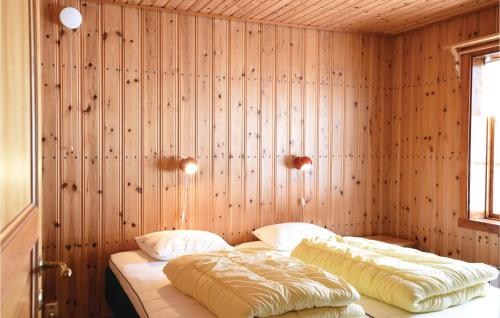 two beds in a room with wooden walls at 2 Bedroom Awesome Home In Sysslebck in Sysslebäck