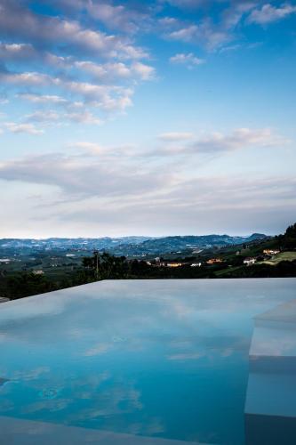 a large swimming pool with a view of a city at Cà del Re in Verduno