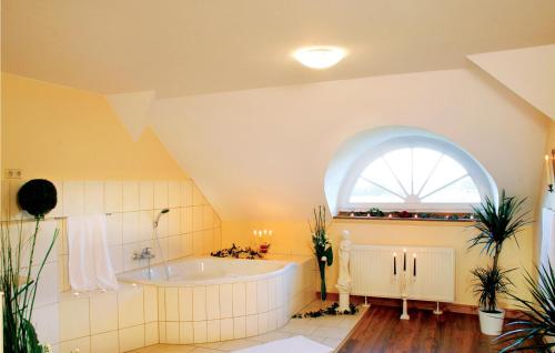 an attic bathroom with a tub and a window at Herrenhaus Lbbenow in Lübbenow
