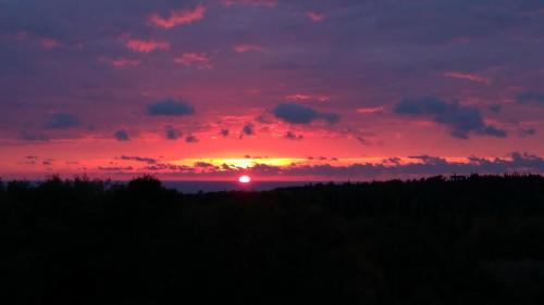 a sunset with the sun setting in the horizon at Le Petit in Čilipi