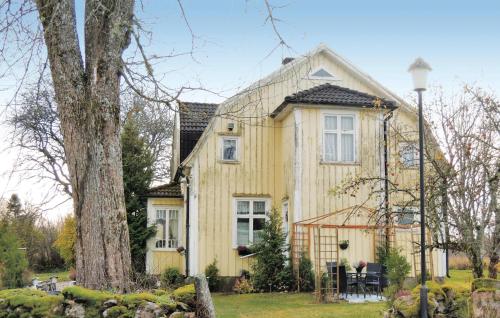 a yellow house with a tree in front of it at Holiday Home Stommen Kärråkra Blidsberg in Älmestad