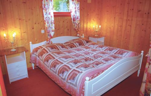een slaapkamer met een bed, 2 tafels en een raam bij 5 Bedroom Awesome Home In Borhaug in Borhaug