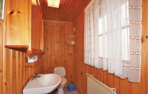 a wooden bathroom with a sink and a toilet at Holiday Home Geterud Hammarö in Hammarö