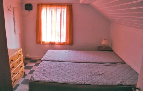 um pequeno quarto com uma cama e uma janela em Awesome Home In Farsund With Lake View em Helle