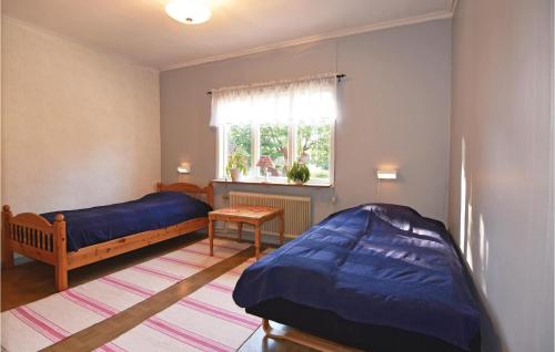 1 dormitorio con 2 camas y ventana en Nice Home In ml With House A Mountain View en Åmål