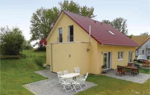 a yellow house with a table and chairs at Two-Bedroom Apartment In Boiensdorf in Boiensdorf