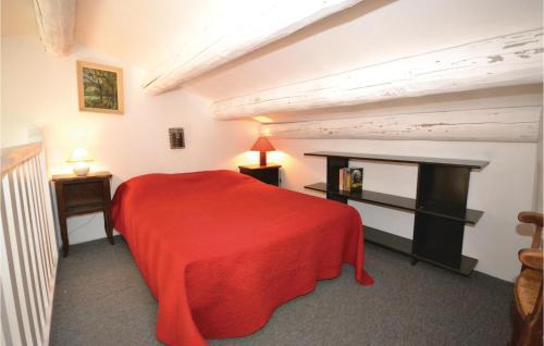 a bedroom with a red bed and a table at Gorgeous Home In Crillon Le Brave With Wifi in Crillon-le-Brave