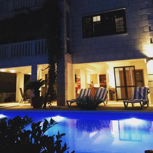 a pool in front of a house at night at Luigi apartments in Dubrovnik