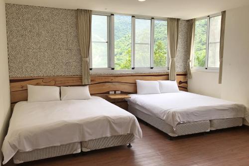 WenquanにあるChihpen Lucky Hot Spring B&Bの窓が2つある部屋にベッドが2つある