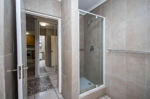 a shower with a glass door in a bathroom at Sorgente 405 with inverter in Umdloti