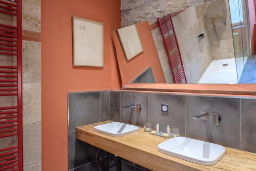 Baño con 2 lavabos y espejo en Hôtel Restaurant d'Alibert en Caunes-Minervois