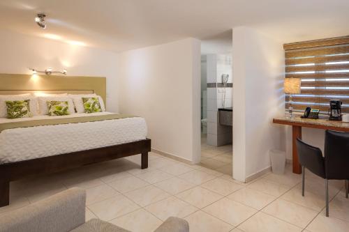 a bedroom with a bed and a bathroom at Hotel Villa Taina in Cabarete