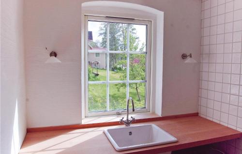 La salle de bains est pourvue d'un lavabo et d'une fenêtre. dans l'établissement Cozy Home In sljunga With Kitchen, à Åsljunga