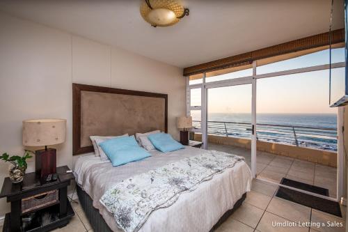 a bedroom with a bed with a view of the ocean at Sugar Beach 2B in Umdloti