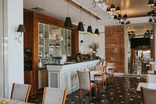 un restaurante con bar, mesas y sillas en Hotel Kamienica, en Siedlce
