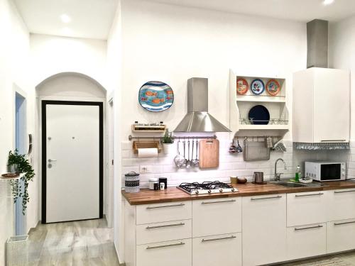 a kitchen with white cabinets and a stove at Mare&Sentieri Apartment in La Spezia