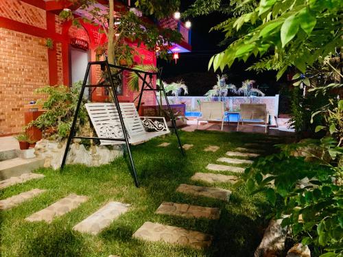 a chair sitting on the grass in a yard at Vu's Homestay in Phong Nha