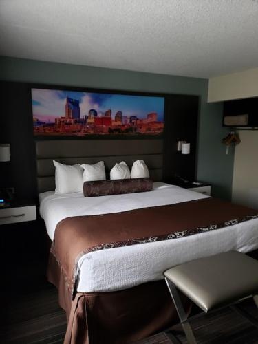 a hotel room with a large bed with a large screen at Club Hotel Nashville Inn & Suites in Nashville