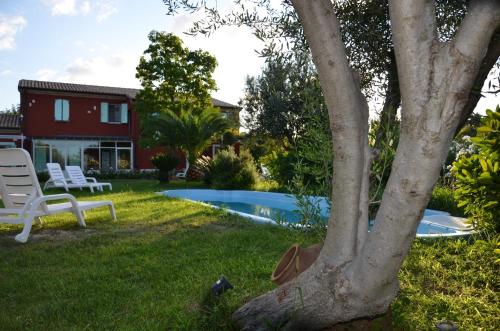 a yard with a pool and a house at Borgo Rosso Country House B&B in Sirolo