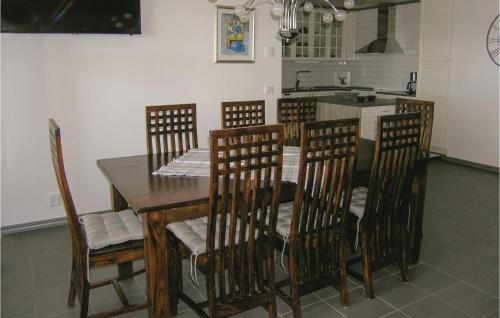 a dining room table with chairs and a kitchen at Awesome Home In Vittaryd With Sauna in Kvänarp