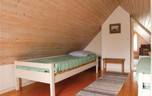 ボリホルムにあるCozy Home In Borgholm With Kitchenの木製の壁のドミトリールームのベッド1台分です。