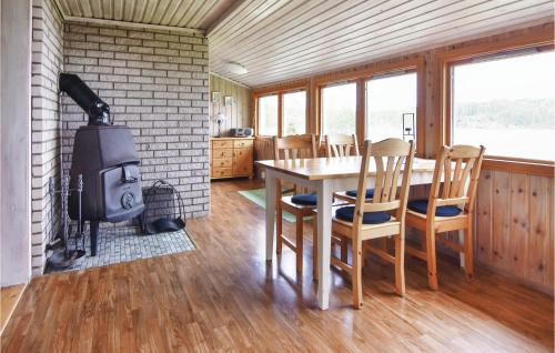 a living room with a table and a fireplace at 2 Bedroom Nice Home In Klässbol in Prästhög