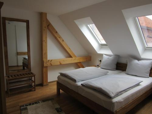 ein Schlafzimmer mit einem Bett und zwei Fenstern in der Unterkunft Feriendomizil Taupadel in Bürgel
