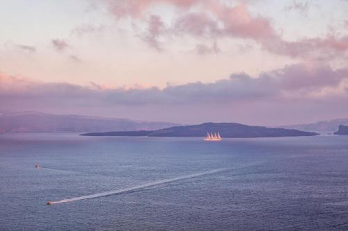 a boat in a large body of water at Diamond Luxury Suites Collection in Oia