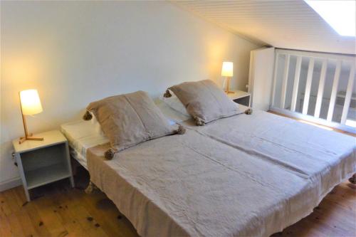 a bedroom with a bed with two lamps and a window at CANELLA 2 in Favone