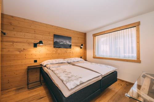 a bedroom with a large bed and a window at Apart Lodge belMont in Saas-Fee