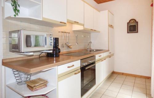a kitchen with white cabinets and a microwave at Ferienhaus 14 In Thalfang in Thalfang