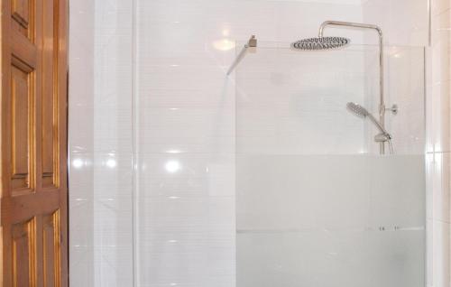 een douche met een glazen deur en een douchekop bij 1 Bedroom Gorgeous Apartment In Rojales in Rojales