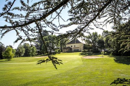 a view of a golf green with a house in the background at Le Grand Hôtel - Domaine De Divonne in Divonne-les-Bains