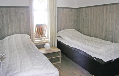 two twin beds in a room with a window at Awesome Home In Vittaryd With Sauna in Kvänarp