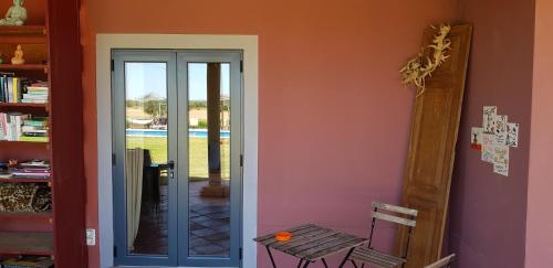 a room with a door and a table in a room at Quinta dos doze Sobreiros - Quarto Sol in Ferreira do Alentejo