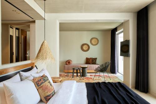 a bedroom with a bed and a living room at The Syntopia Hotel - Adults Only in Adelianos Kampos