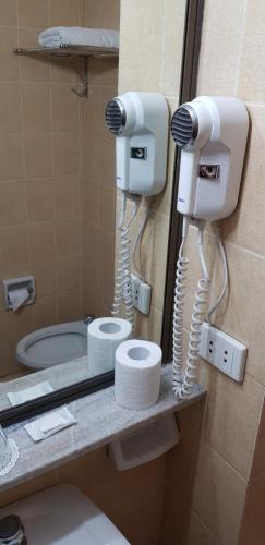 a bathroom with two hair dryers and a toilet at Hotel Yaguaron in San Nicolás de los Arroyos