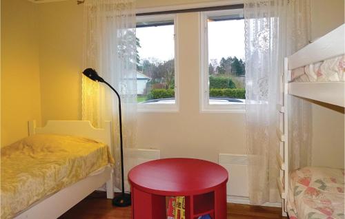 Beddinge StrandにあるLovely Home In Beddingestrand With Wifiの窓の前に赤いスツールが付いたベッドルーム