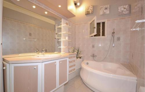 a bathroom with a tub and a toilet and a sink at 1 Bedroom Awesome Home In Visan in Visan