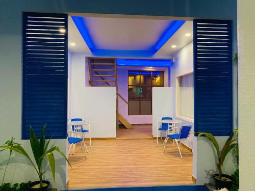a room with chairs and tables and a blue ceiling at Hudhuvelimaldives in Omadhoo